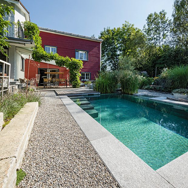 Naturpool mit Steinbegrenzung und Steinstufen