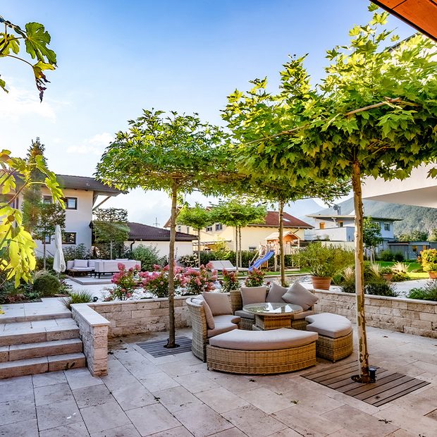 Outdoorbereich mit Steinmauern, Steinterrasse und Outdoormöbeln